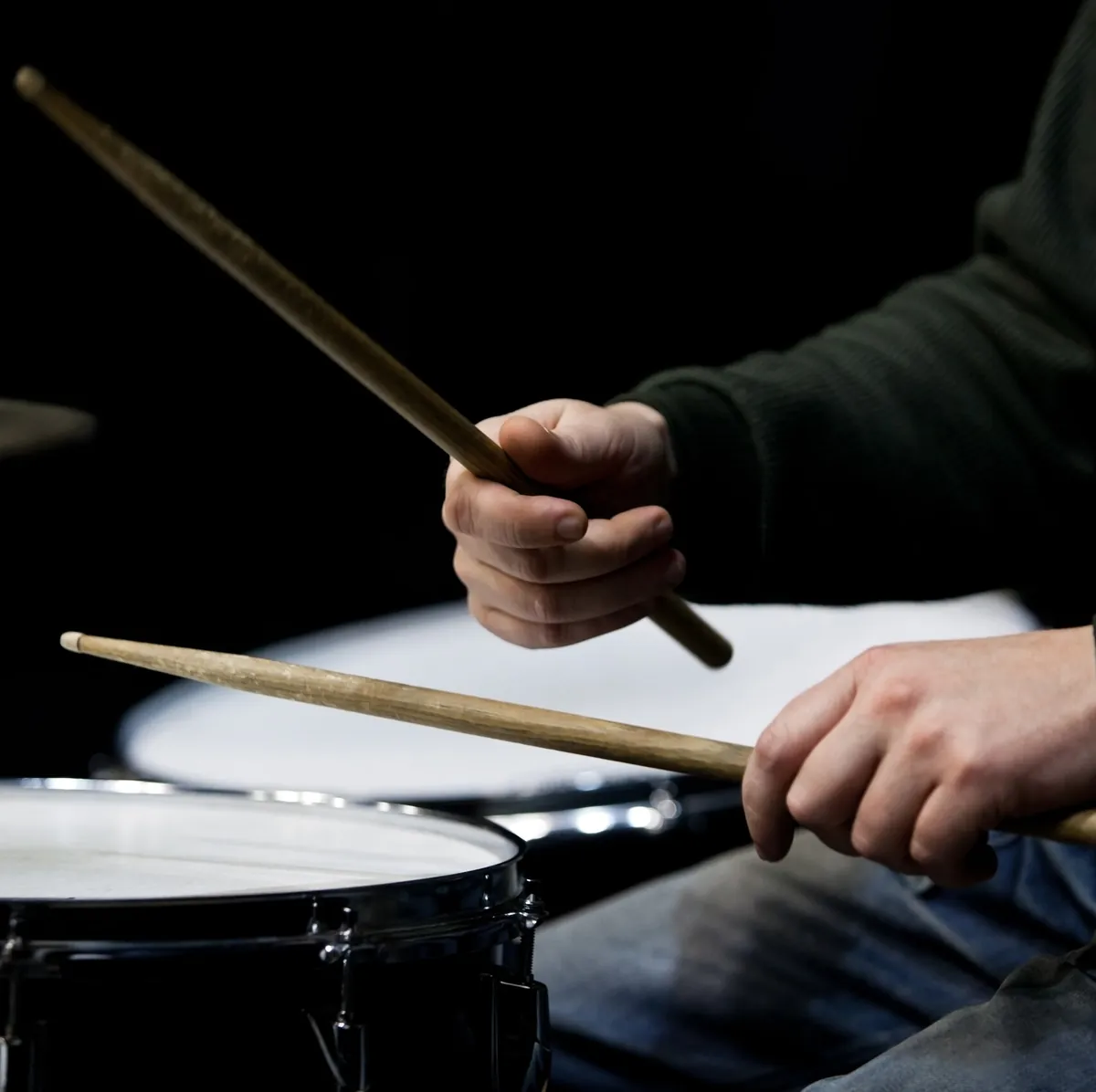 Mains d’un batteur avec ses baguettes