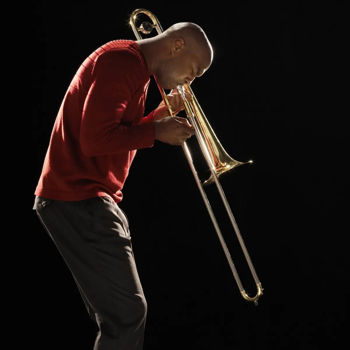 Tromboniste en pull rouge sur fond noir